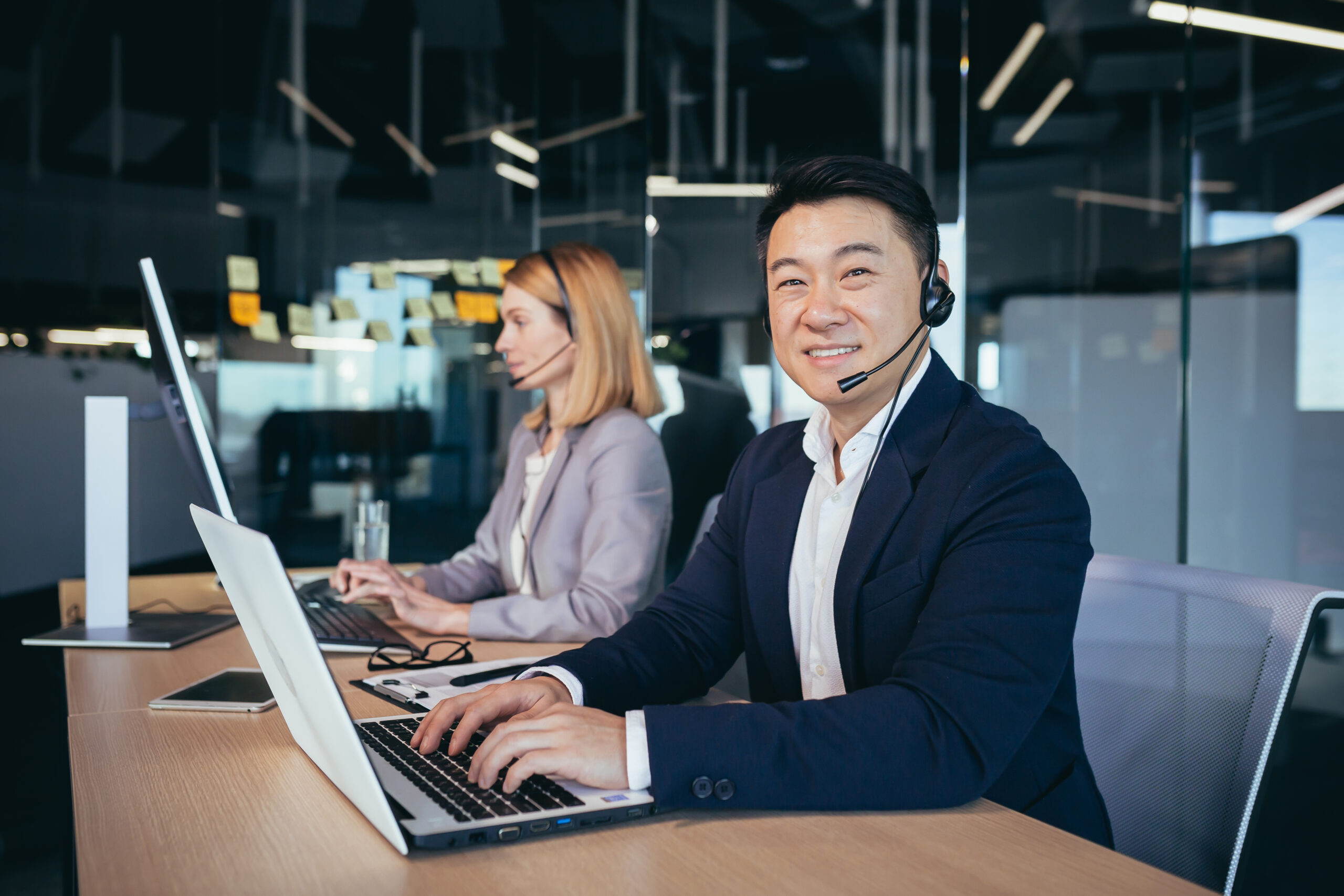 Male asian businessman uses headset for video communication, business man looking at camera Male asian businessman uses headset for video communication, business man looking at camera and smiling
